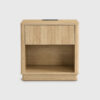Light wood ribbed nightstand with open storage shelf, wireless charging station, and built-in USB power outlets in a modern bedroom setting