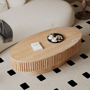 Modern oval storage coffee table with ribbed wood finish and lift top, placed in a cozy contemporary living room with boucle sofa